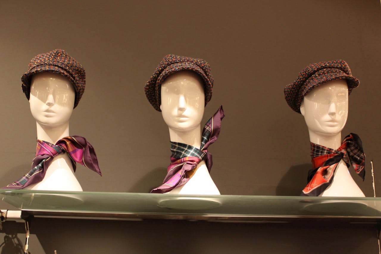 services-01 Elegant display of hats and scarves on mannequins in Paris shop window.